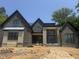 New home construction featuring dark brick, stone accents, and a modern design under a clear blue sky at 504 Colvard Woods Way Way, Durham, NC 27713