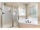 Bright bathroom featuring a tub and walk-in shower with decorative glass block windows allowing natural light at 3009 Gentle Breezes Ln, Raleigh, NC 27614