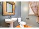 Quaint powder room with pedestal sink, ornate mirror, and neutral paint at 3009 Gentle Breezes Ln, Raleigh, NC 27614