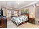 Comfortable bedroom featuring a tray ceiling, neutral walls, two windows, and a leather bed frame at 3009 Gentle Breezes Ln, Raleigh, NC 27614