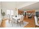 Dining room with a white table and upholstered chairs and an open view to the kitchen and bar area at 3009 Gentle Breezes Ln, Raleigh, NC 27614