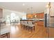 Open kitchen with island seating, stainless appliances, and a view to the dining area at 3009 Gentle Breezes Ln, Raleigh, NC 27614
