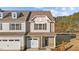 Two-story townhome with gray and beige siding, stone accents, and a two-car garage at 804 Pryor St # 49, Mebane, NC 27302