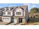 Two-story townhome with gray and beige siding, stone accents, and a two-car garage at 804 Pryor St # 49, Mebane, NC 27302