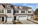Tan three-story townhome with white garage doors, and landscaping at 806 Pryor St # 50, Mebane, NC 27302