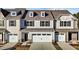 Beige three-story townhome with white garage doors, and landscaping at 806 Pryor St # 50, Mebane, NC 27302