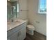 Bright bathroom featuring a single sink vanity, a window, and a toilet at 236 Alden Way, Angier, NC 27501