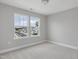 Neutral bedroom featuring neutral carpeting, white trim, and two large windows with outside view at 236 Alden Way, Angier, NC 27501
