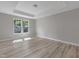 Spacious bedroom with a tray ceiling, neutral paint, and large windows at 236 Alden Way, Angier, NC 27501