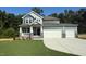 Inviting home featuring a two-car garage, covered porch, stone accents, and well-manicured lawn at 236 Alden Way, Angier, NC 27501