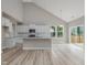 Spacious kitchen with white cabinets, a granite island, stainless steel appliances, and hardwood floors, connected to a large living area at 236 Alden Way, Angier, NC 27501