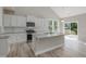 Modern kitchen featuring white cabinets, granite countertops, stainless steel appliances, and hardwood floors, perfect for cooking at 236 Alden Way, Angier, NC 27501