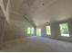 Bright, unfinished living room with vaulted ceilings, large windows, and access to outdoor space at 236 Alden Way, Angier, NC 27501