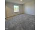 Bright, carpeted bedroom featuring a window with natural light, neutral walls, and plenty of open space at 1050 Mountain Crown St, Durham, NC 27703