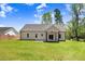 Exterior view of the home featuring a spacious backyard, patio, and neutral siding at 6965 Us-401, Fuquay Varina, NC 27526