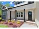 Inviting front porch with black columns and a nicely landscaped flower bed at 6965 Us-401, Fuquay Varina, NC 27526