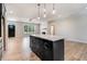 Open kitchen island view with black cabinetry, leading to a living area with a fireplace and a black front door at 6965 Us-401, Fuquay Varina, NC 27526