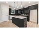 Contemporary kitchen with black cabinetry, stainless steel appliances, and a central island under pendant lights at 6965 Us-401, Fuquay Varina, NC 27526