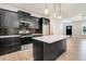 Open-concept kitchen with sleek black cabinets, stainless steel appliances, and a quartz-topped island at 6965 Us-401, Fuquay Varina, NC 27526