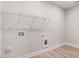 This laundry room features wood look floors, shelving, and washer and dryer hookups at 6965 Us-401, Fuquay Varina, NC 27526