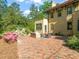 Brick patio with outdoor seating, surrounded by lush landscaping and mature trees at 1015 Minerva Ave, Durham, NC 27701