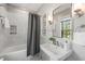 A serene bathroom with tub and shower, complemented by a stylish vanity and updated fixtures at 1015 Minerva Ave, Durham, NC 27701