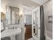 Classic bathroom with pedestal sink, tiled walls, and mirrored door to the bedroom at 1015 Minerva Ave, Durham, NC 27701