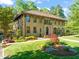 A sprawling brick home with a red tile roof and meticulously landscaped front yard at 1015 Minerva Ave, Durham, NC 27701