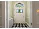 Inviting foyer with black and white tiled floor, radiator, and arched doorway at 1015 Minerva Ave, Durham, NC 27701