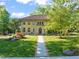 Stunning two-story brick home with a red tile roof, manicured lawn, and colorful landscaping at 1015 Minerva Ave, Durham, NC 27701