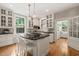 Well-lit kitchen with an island featuring a cooktop, white cabinetry, and hardwood floors, plus a window seat at 1015 Minerva Ave, Durham, NC 27701