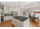 Spacious kitchen featuring a large center island with cooktop and black countertops, and stainless steel appliances at 1015 Minerva Ave, Durham, NC 27701