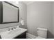 Chic powder room with a marble countertop vanity, modern faucet, and tile flooring at 1015 Minerva Ave, Durham, NC 27701