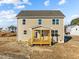 An exterior back view of the two-story home has a wooden porch that leads to the backyard at 15 Diamond Creek Dr, Zebulon, NC 27597