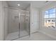 Modern bathroom featuring glass-enclosed shower, tile surround, and a window for natural light at 15 Diamond Creek Dr, Zebulon, NC 27597