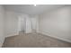 Bedroom boasts neutral carpet, white trim, an electrical outlet, and a closet or doorway that leads to other rooms at 15 Diamond Creek Dr, Zebulon, NC 27597