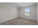 Bedroom offers neutral carpet, white walls, a double hung window with a view of the outdoors, and electrical outlets at 15 Diamond Creek Dr, Zebulon, NC 27597