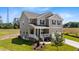 Charming two-story home with a front porch, attached garage, and well-maintained landscaping at 15 Diamond Creek Dr, Zebulon, NC 27597