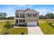 Charming two-story home with a front porch, attached garage, and well-maintained landscaping at 15 Diamond Creek Dr, Zebulon, NC 27597