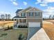 Two-story house with a neutral color scheme, a two-car garage, and a landscaped yard at 15 Diamond Creek Dr, Zebulon, NC 27597