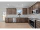 Modern kitchen with dark brown cabinets, white backsplash, and stainless steel appliances at 15 Diamond Creek Dr, Zebulon, NC 27597