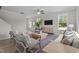 Bright living room with modern furniture, ceiling fan, and large windows offering natural light and outdoor views at 15 Diamond Creek Dr, Zebulon, NC 27597