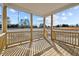 The wooden porch has wooden columns, railings, and flooring, along with a view of trees and the field at 15 Diamond Creek Dr, Zebulon, NC 27597