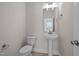 Neat half bathroom with a pedestal sink, modern toilet, and a large mirror at 15 Diamond Creek Dr, Zebulon, NC 27597