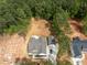 New home aerial view features a driveway, landscaping, wooded lot, and a foundation being built nearby at 205 Purslane Dr, Franklinton, NC 27525