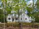 Front exterior showcasing a white house with charming curb appeal and surrounded by lush, green trees at 205 Purslane Dr, Franklinton, NC 27525