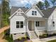 Charming home with stone accents, white siding, landscaped yard, and a welcoming front porch with stone steps at 205 Purslane Dr, Franklinton, NC 27525