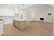 Open concept kitchen and living room featuring a fireplace, white cabinets, and a kitchen island at 205 Purslane Dr, Franklinton, NC 27525