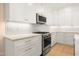 Kitchen with stainless steel appliances, white cabinetry, and stone countertops at 205 Purslane Dr, Franklinton, NC 27525