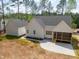 Aerial view showcasing a home's backyard with a screened-in porch, concrete patio, and lush surroundings at 205 Purslane Dr, Franklinton, NC 27525